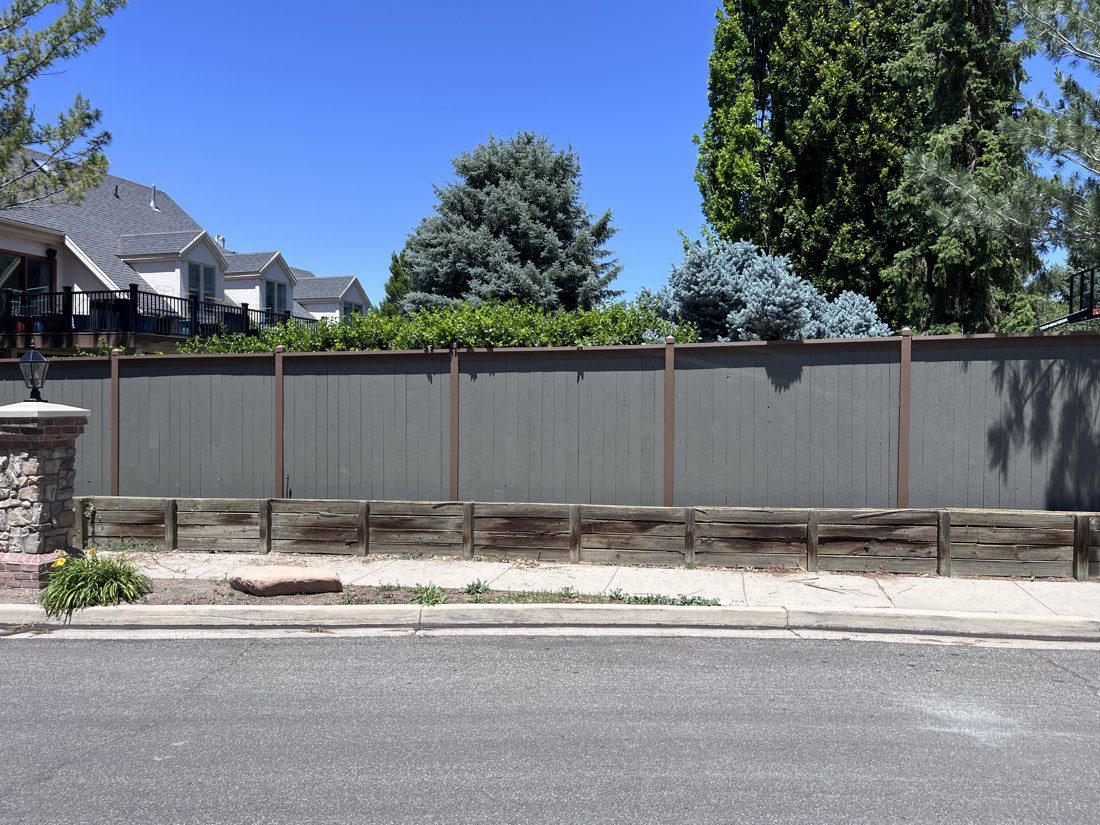Freshly stained two-tone privacy fence along a Salt Lake City street