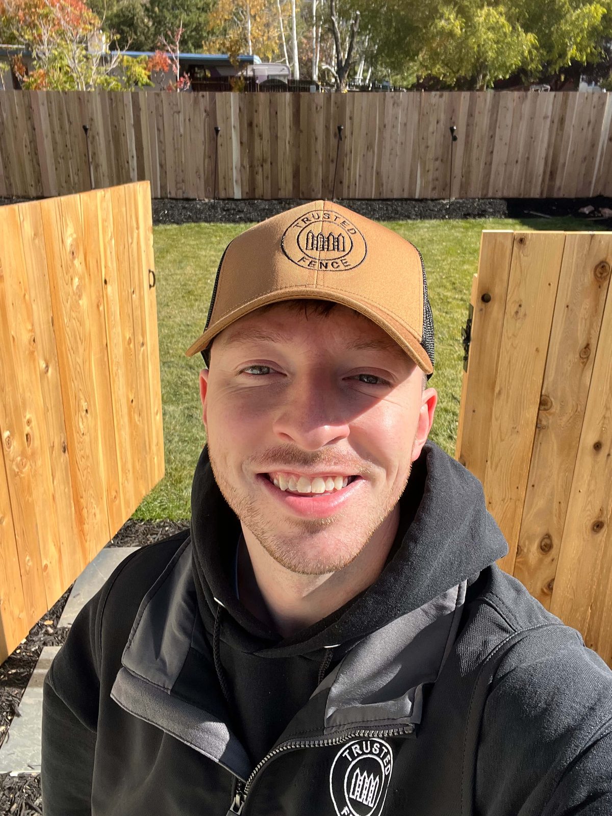 Landon Mickelson, owner of Trusted Fence, in branded gear on a job site