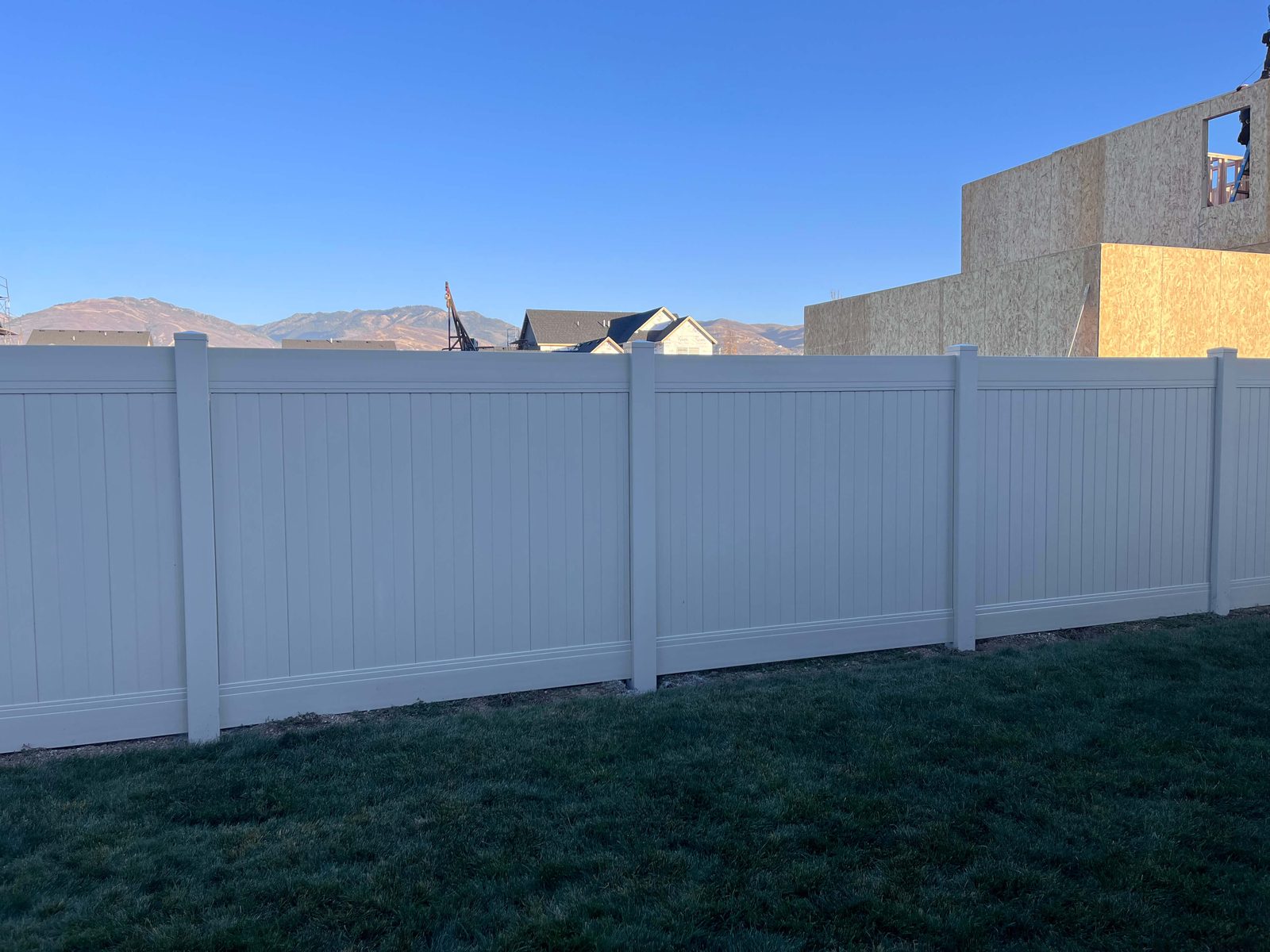White vinyl privacy fence on a new-construction lot in the Salt Lake Valley, installed by Trusted Fence