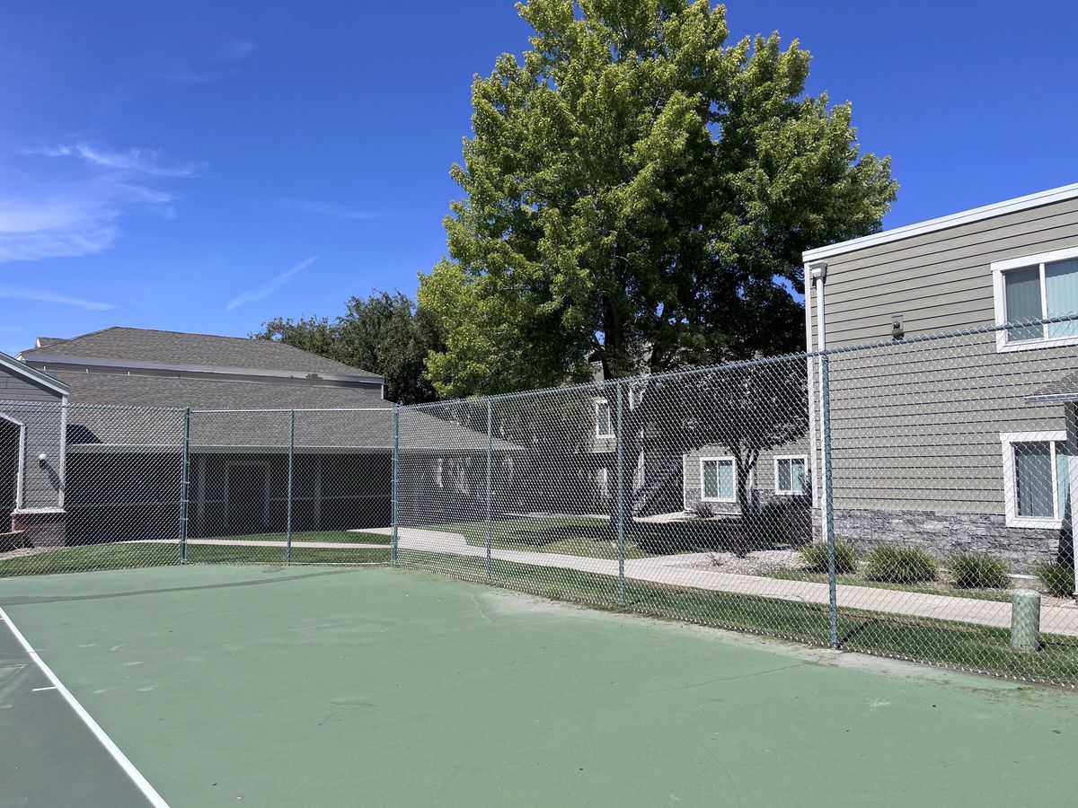 Galvanized chain link fence around a sport court beside townhome buildings in the Salt Lake Valley