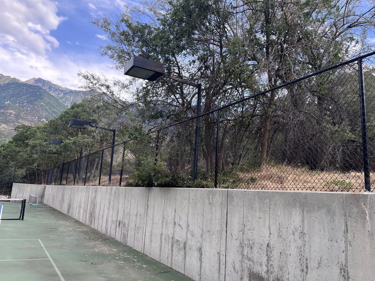 Black chain link fence on a retaining wall above a sport court in the Salt Lake Valley