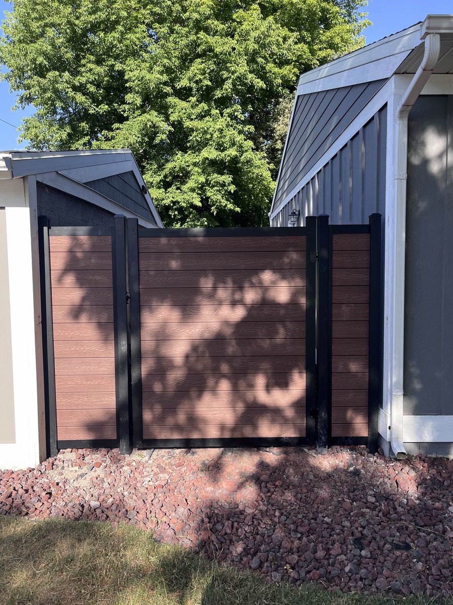Woodgrain composite privacy fence and walk gate with black posts in South Jordan, UT