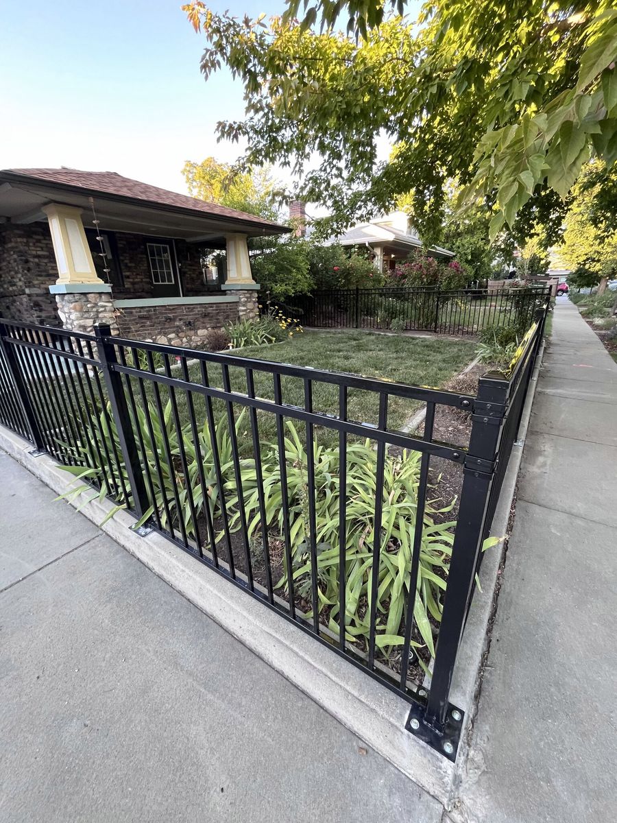 Black ornamental iron fence along a sidewalk in front of a craftsman style home in Cottonwood Heights, UT